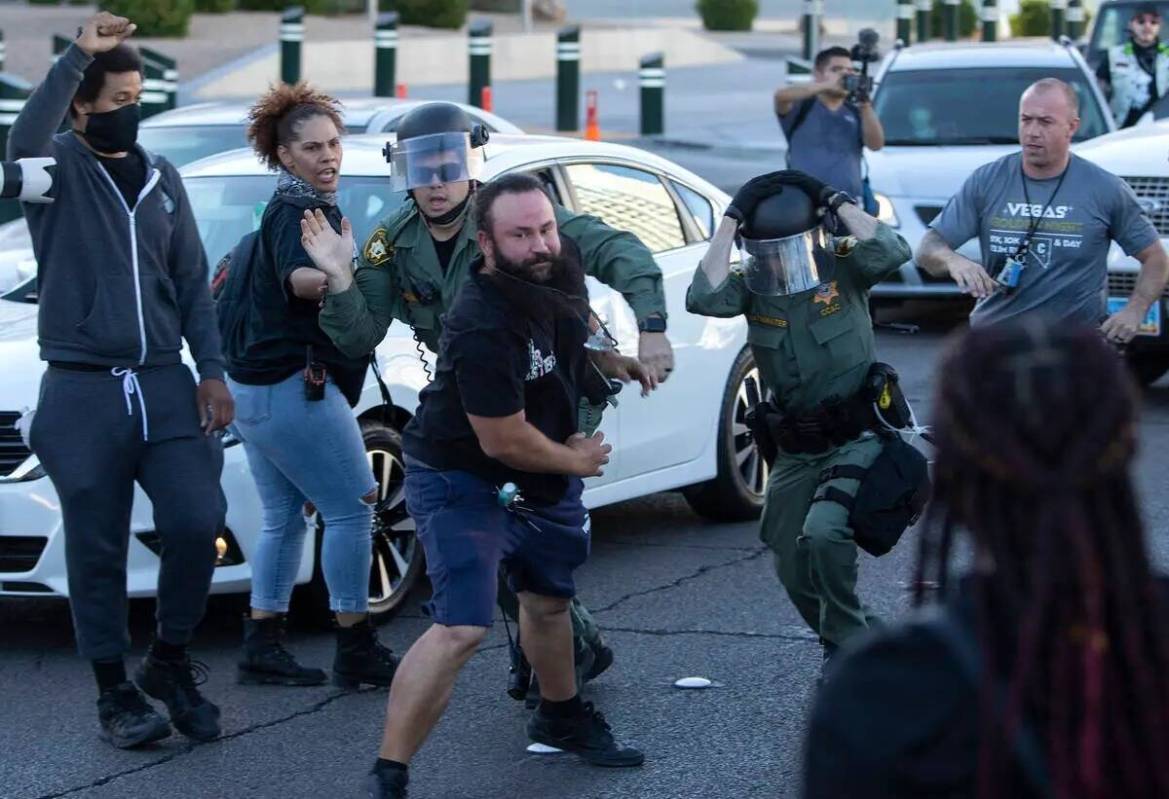 Un manifestante se escapa mientras la policía intenta arrestarlo durante una marcha contra la ...