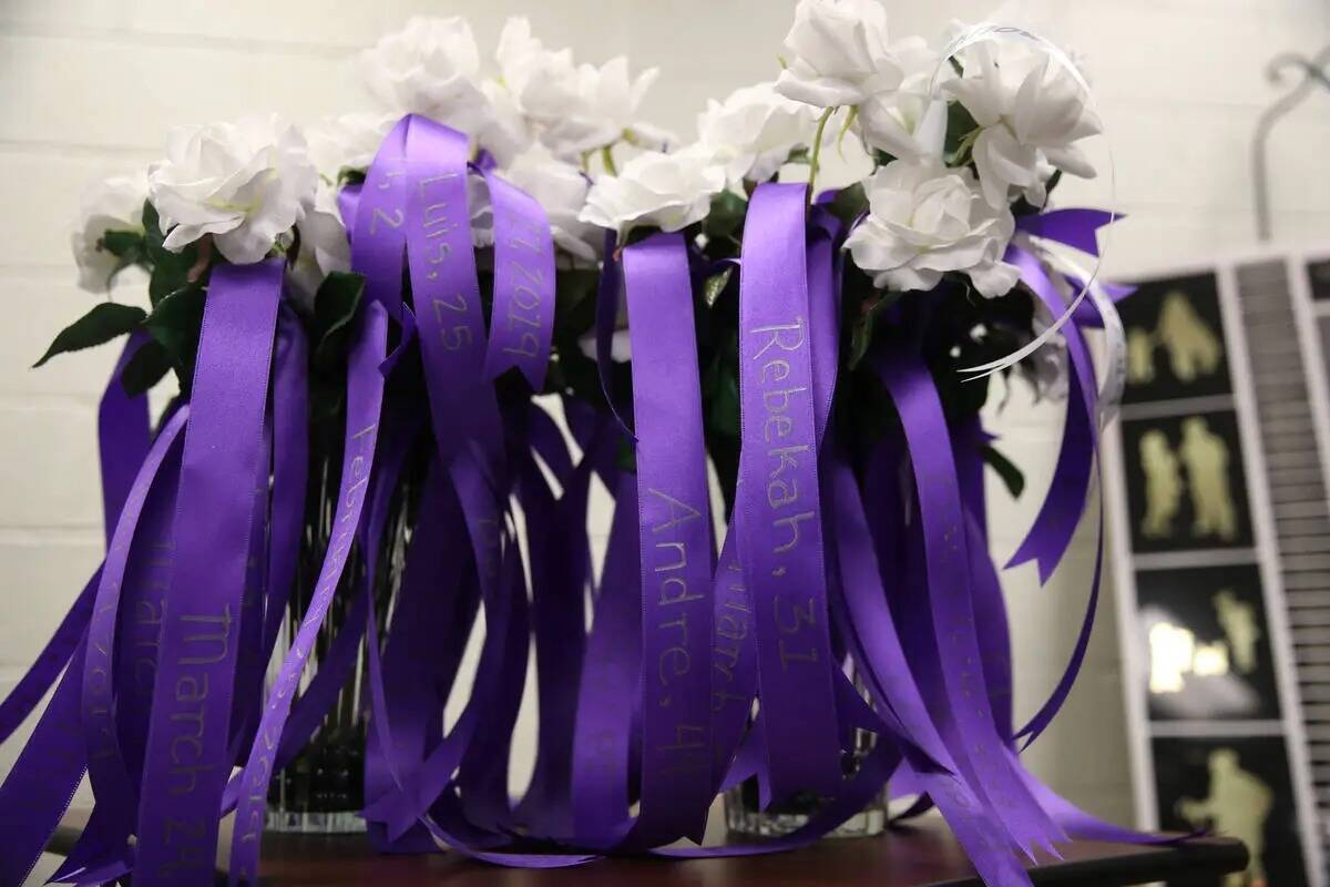Flores con los nombres de las víctimas de la violencia doméstica se muestran durante una cere ...
