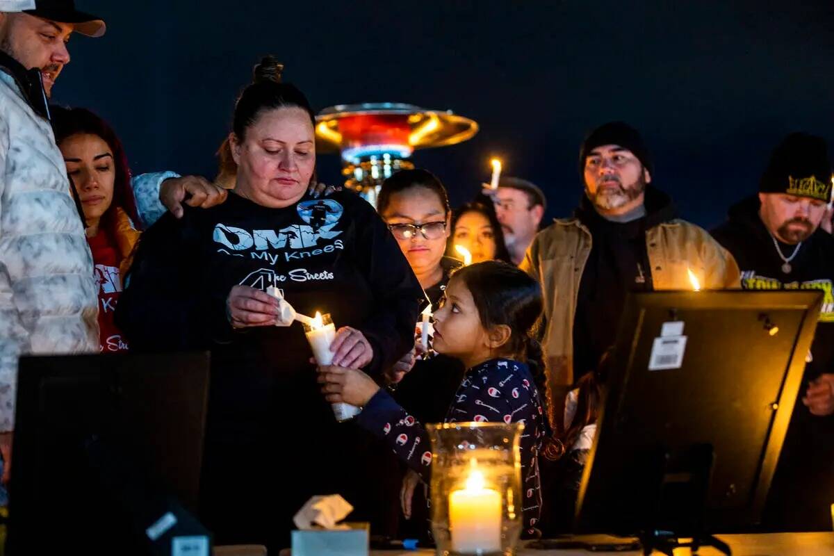La esposa Angela Dominguez, al centro, enciende una vela para una niña mientras ellas y otros ...