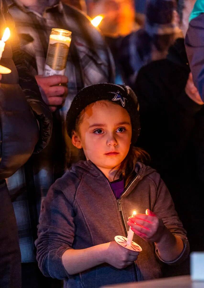 Una niña sostiene una vela mientras ellos y otros honran a Jonet Dominguez durante una vigilia ...