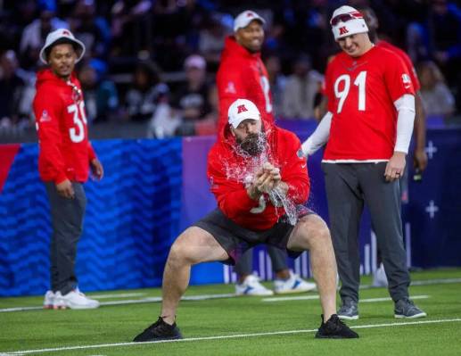 El jugador de la AFC Mitch Morse (60), de los Bills, hace explotar su globo en la prueba de cap ...
