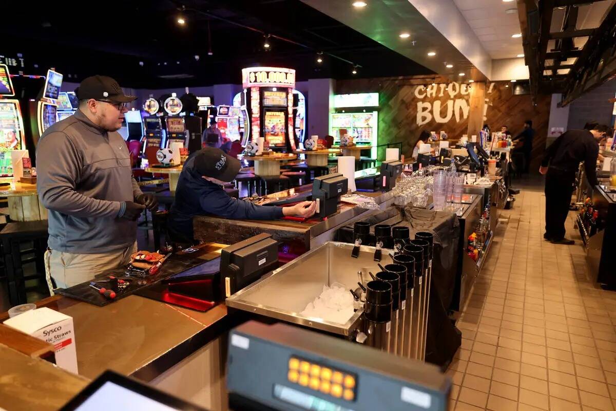 Trabajadores instalan máquinas de juego de bar en el nuevo Ojos Locos Sports Cantina y Casino ...