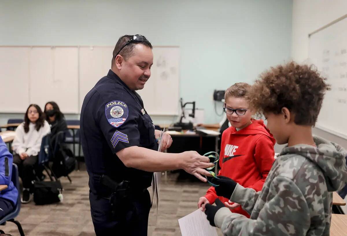 El agente de Policía del Distrito Escolar del Condado Clark, Juan Wibowo, entrega un brazalete ...