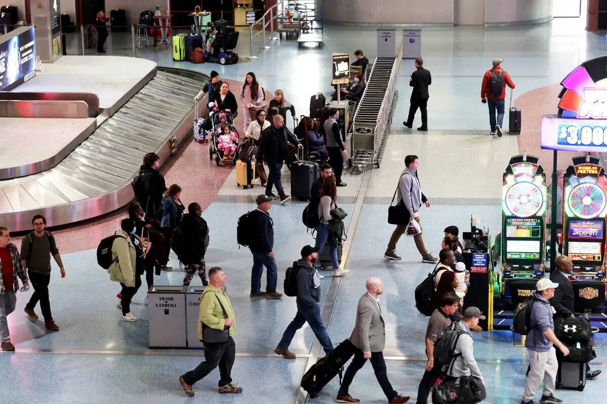 Pasajeros caminan por la recolección de equipaje en la terminal 1 del Aeropuerto Internacional ...