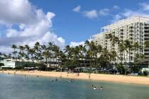 La gente se relaja en la playa y en el agua frente a Kahala Hotel & Resort en Honolulu el domin ...