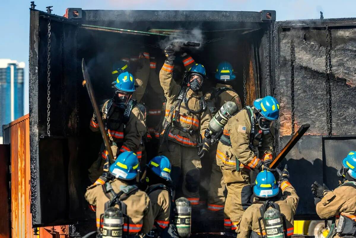 Los reclutas del Departamento de Bomberos del Condado Clark retiran material quemado de un remo ...