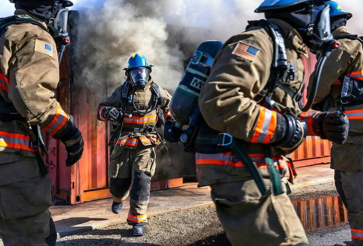 Los reclutas del Departamento de Bomberos del Condado Clark salen de un remolque lleno de humo ...