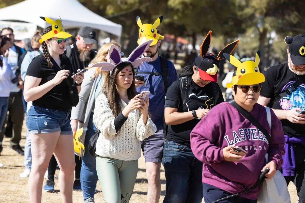 Participantes en el Tour Pokémon Go: Hoenn - Las Vegas navegan por Sunset Park mientras juegan ...