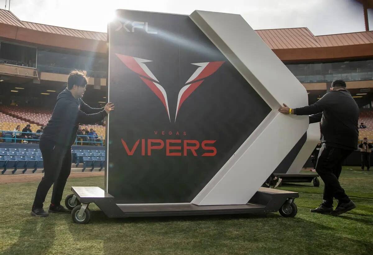 Unos trabajadores sacan un letrero de los Vegas Vipers antes de un partido de fútbol americano ...