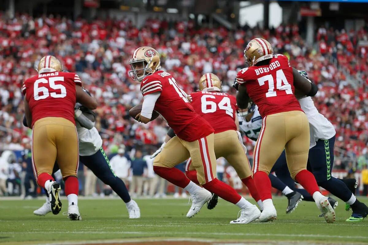 El quarterback de los San Francisco 49ers Jimmy Garoppolo (10) busca entregar el balón durante ...