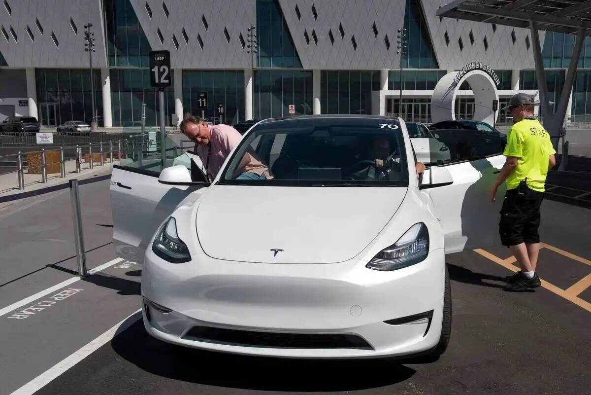 Andy Cameron, a la izquierda, de Wyoming, se sube a un Tesla en la estación Vegas Loop West en ...