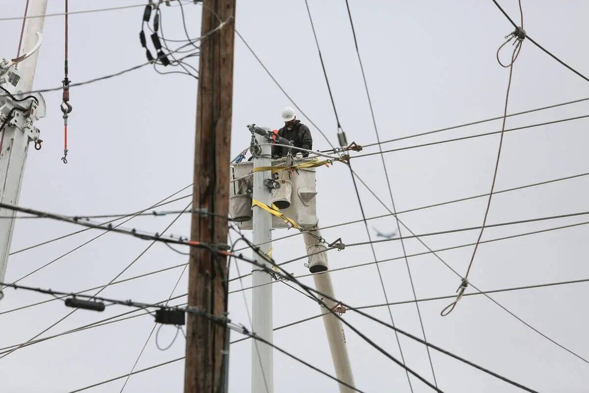 Los trabajadores de NV Energy arreglan las líneas eléctricas que cayeron en la intersección ...