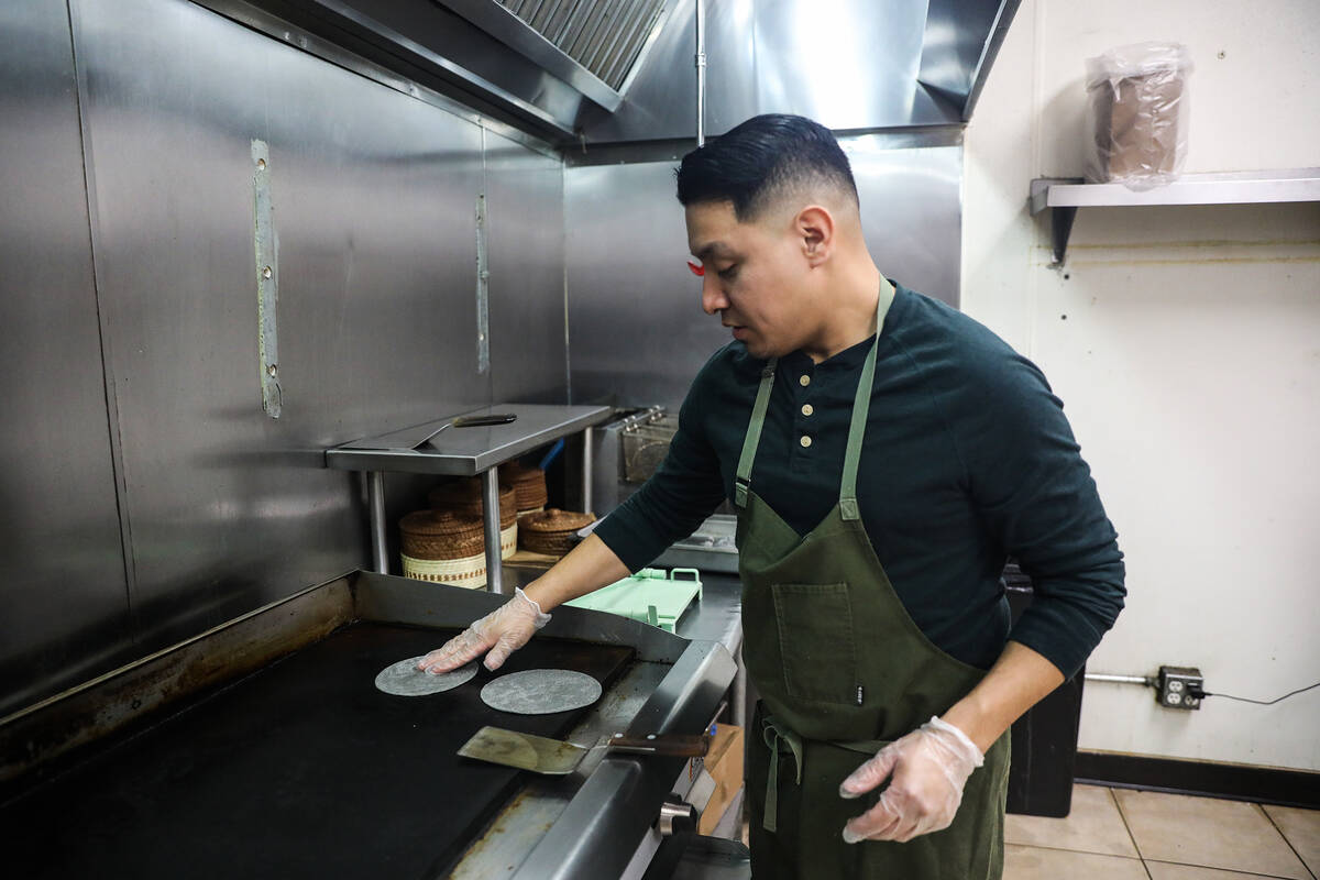El chef DJ Flores usa masa recién hecha para crear tortillas de maíz en Milpa, su restaurante ...
