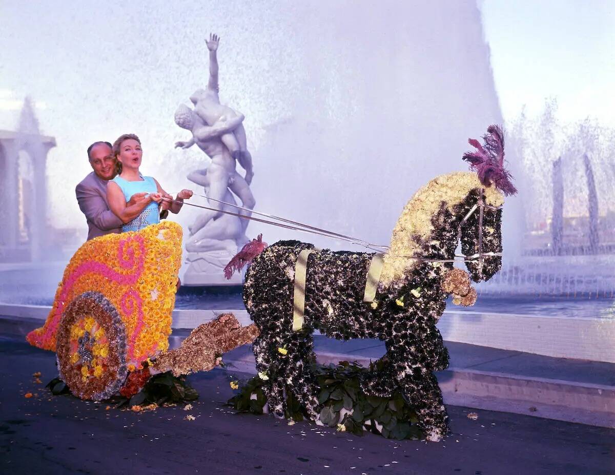 Jay Sarno y fila Renaud posan en un carruaje cerca de las fuentes y la réplica de la estatua d ...
