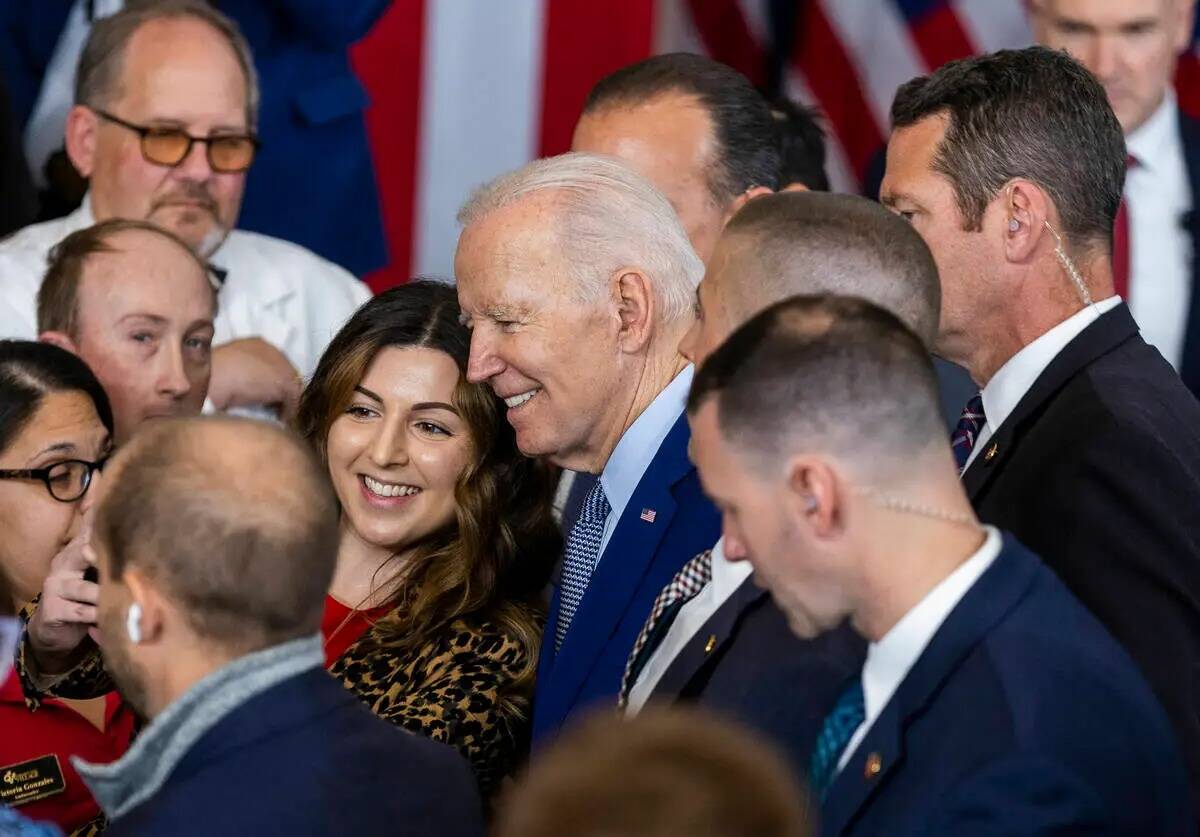 El presidente Joe Biden se toma una foto con un asistente después de hablar sobre la reducció ...