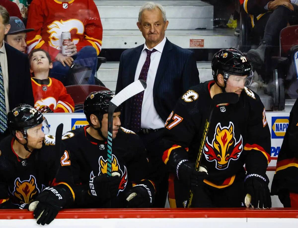 El entrenador de los Calgary Flames, Darryl Sutter, en el centro, observa la jugada durante el ...