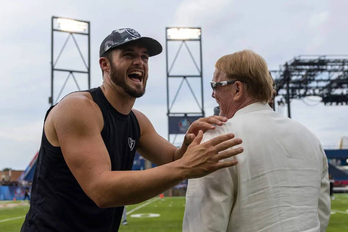 El quarterback de los Raiders Derek Carr, a la izquierda, comparte una risa con el dueño Mark ...