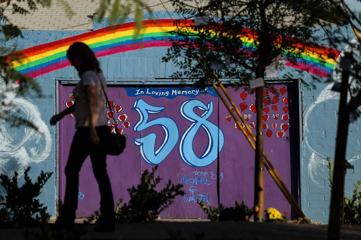 Una mujer camina junto a un mural cerca de un monumento en Las Vegas Community Healing Garden e ...