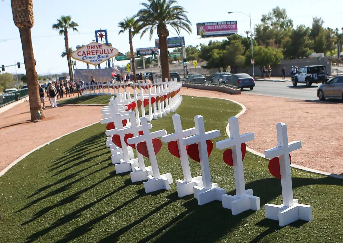 La gente toma fotos de cruces cerca del letrero "Welcome to Fabulous Las Vegas" en Las Vegas el ...