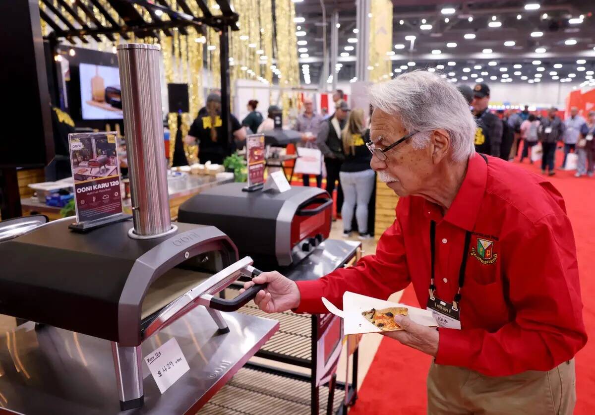 John Fablo, de Las Vegas, revisa los hornos de pizza en el stand de Ooni en la International Pi ...