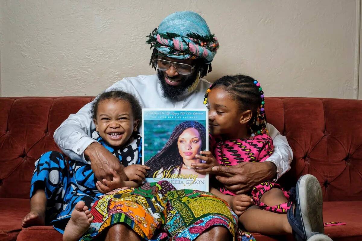 En esta foto proporcionada por Henry Danner, Omari Maynard se sienta con sus hijos, Khari, izqu ...
