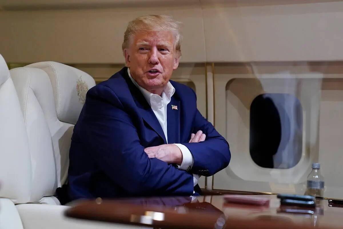 ARCHIVO - El expresidente Donald Trump habla con los reporteros durante el vuelo en su avión d ...