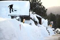 El dueño Brang Miller quita la nieve del tejado de Mammoth Fun Shop en Mammoth Lakes, Californ ...