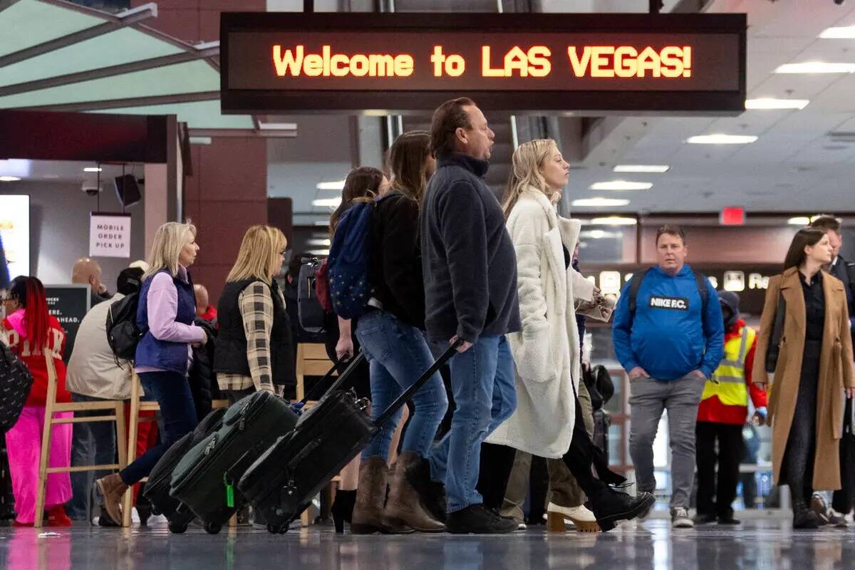 La gente llega a la zona de reclamo de equipaje de la Terminal 1 del Aeropuerto Internacional H ...