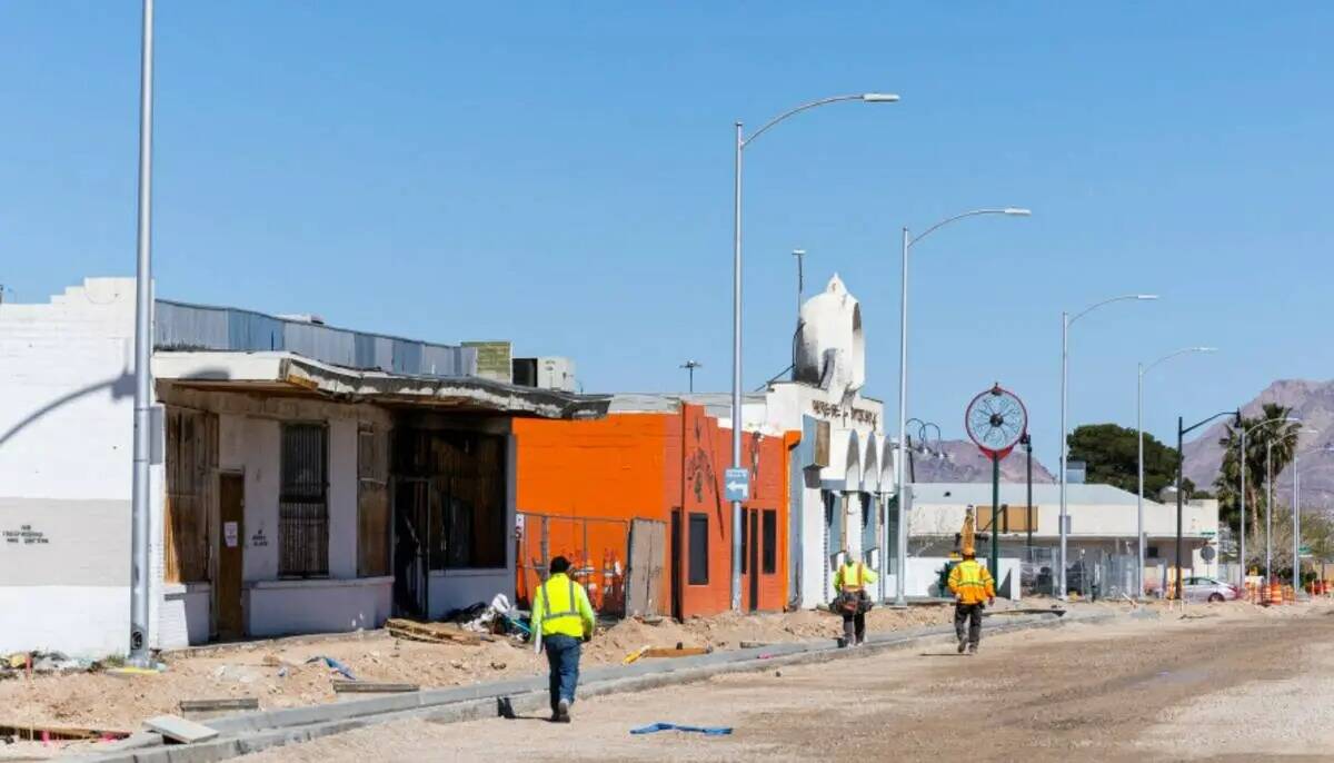 Trabajadores de la carretera caminan a lo largo de Jackson Avenue cerca de un terreno, fuera de ...