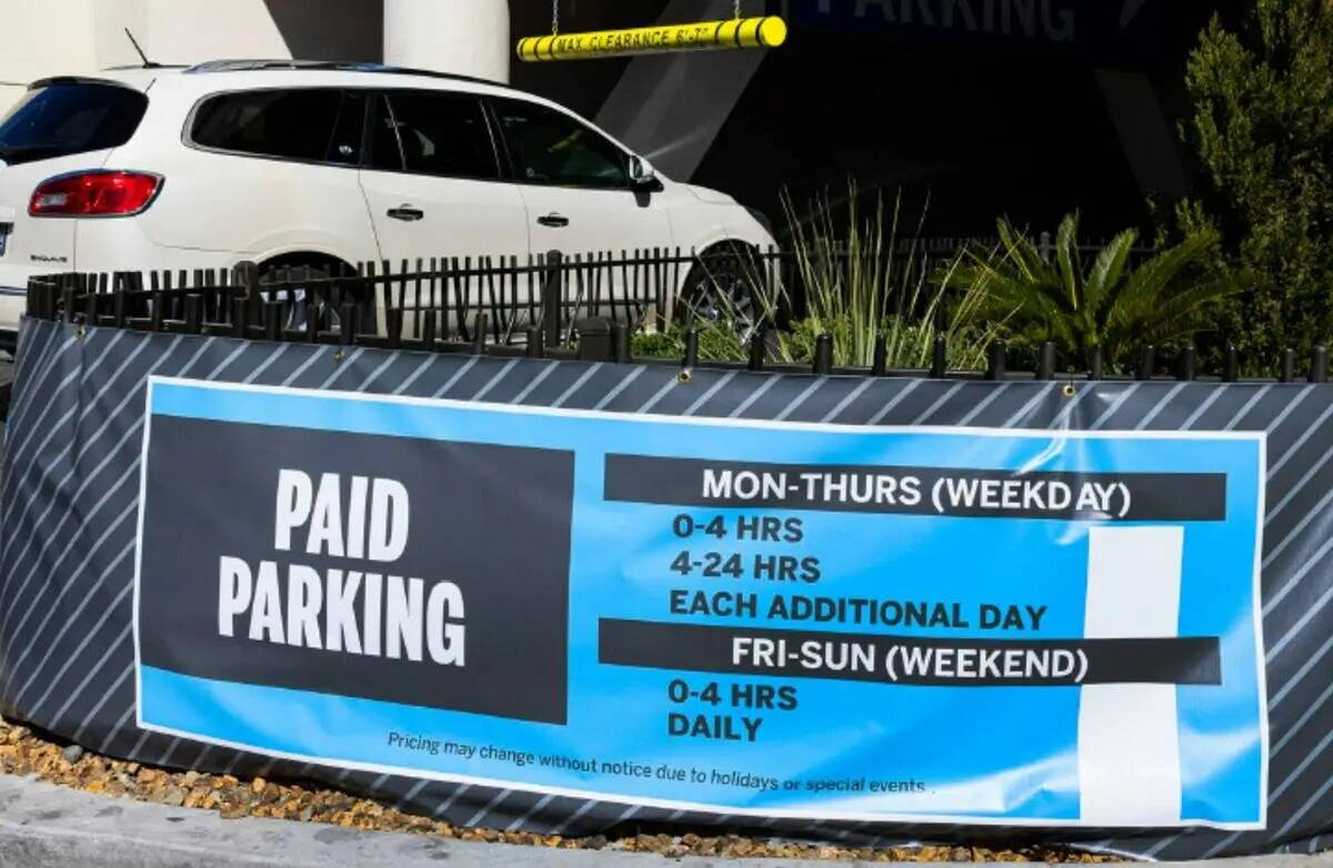 Señal de estacionamiento de pago mientras un auto entra en un estacionamiento de The Strat en ...
