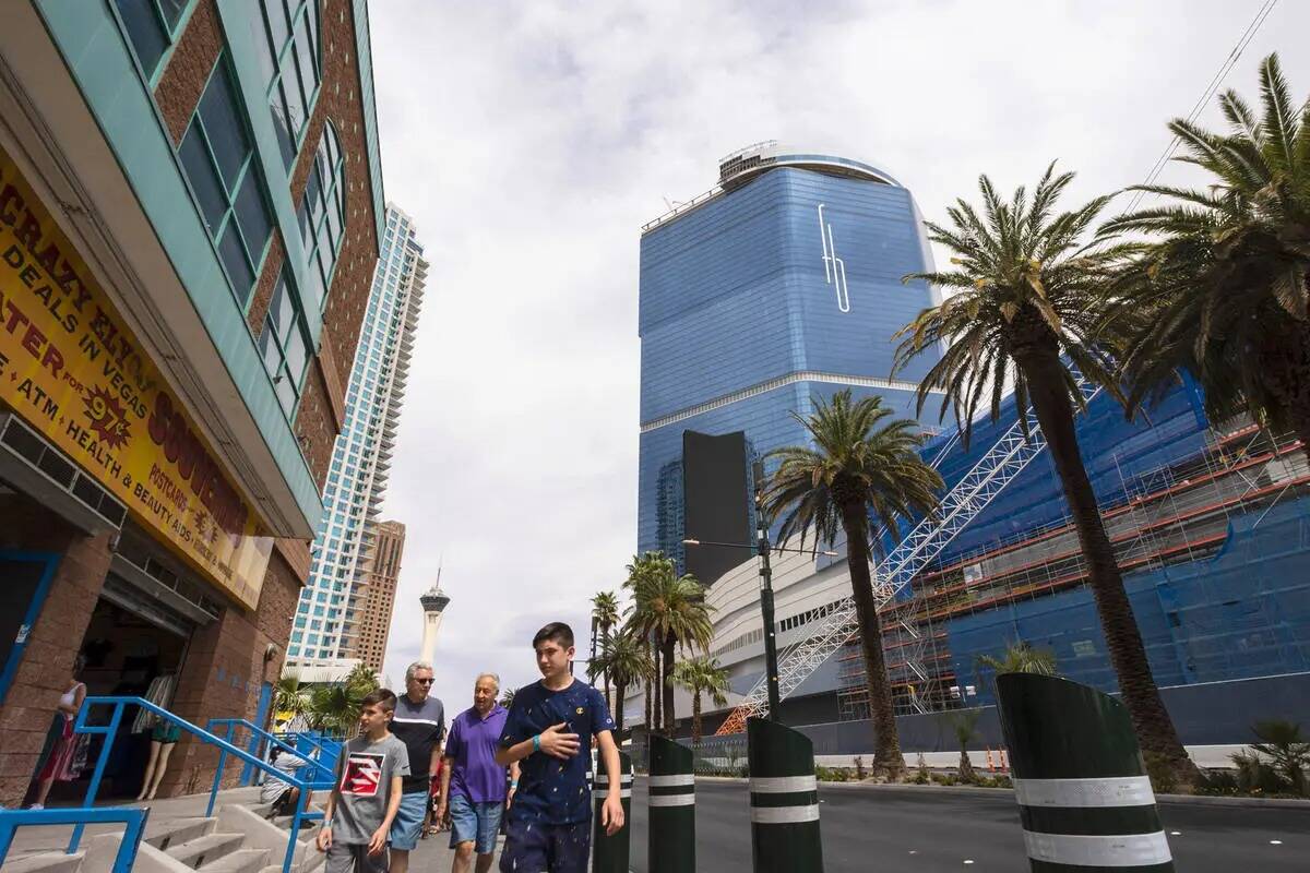 Los peatones pasan por delante del Fontainebleau Las Vegas en construcción, a la derecha, el m ...