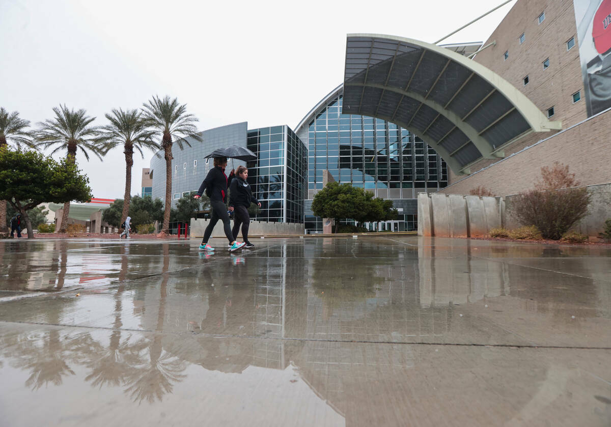 Personas caminan bajo la lluvia por el campus de la UNLV, el martes 14 de marzo de 2023, en Las ...