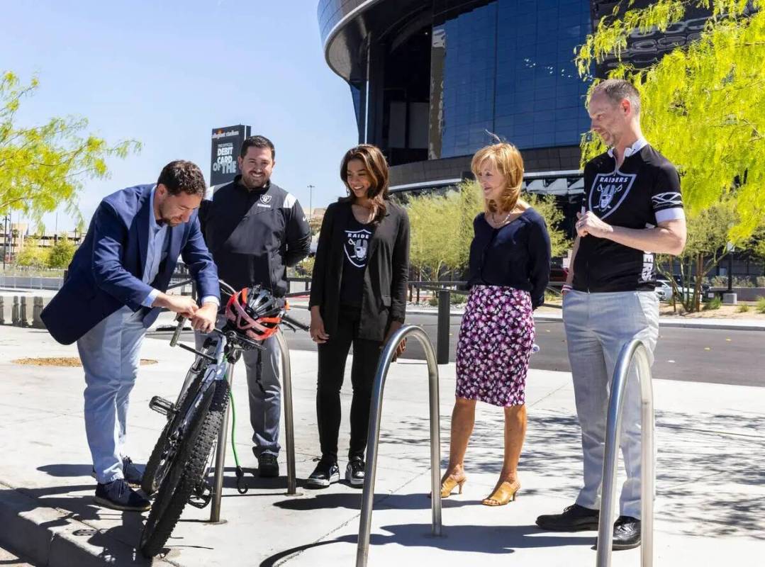 El comisionado del Condado Clark, Michael Naft, fija una bicicleta en un portabicicletas mientr ...