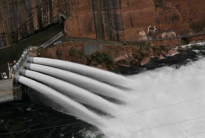 El agua es liberada de la presa Glen Canyon, cerca de Page, Arizona, en 2004. (AP Photo/Laura R ...