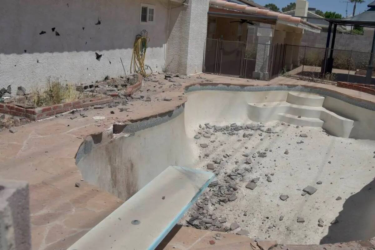 Una piscina con fragmentos de ladrillo se ve después de un Kia pasara a través de una pared y ...