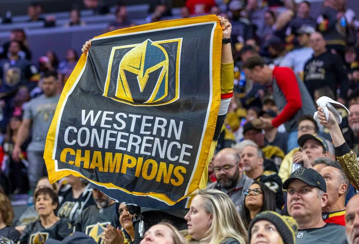 Un fan sostiene una pancarta de los campeones de la West Conference mientras los Golden Knights ...