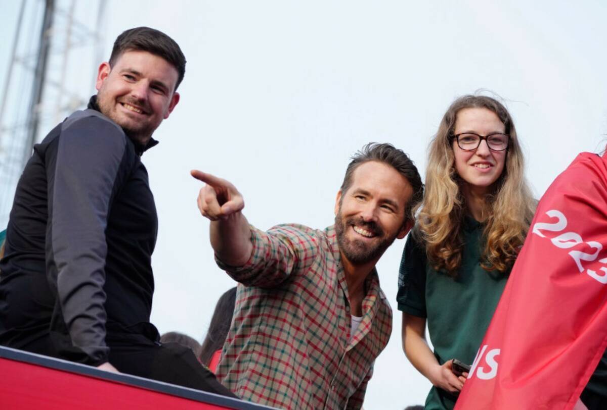 El copropietario del Wrexham, Ryan Reynolds, en el centro, celebra con miembros del equipo de f ...
