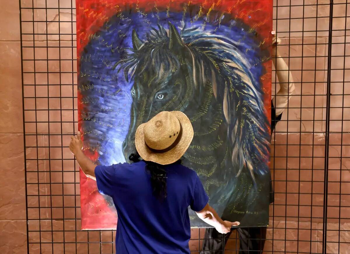 El artista mexicano visitante Olegario Hernández Mendoza cuelga algunas de sus obras en la rot ...