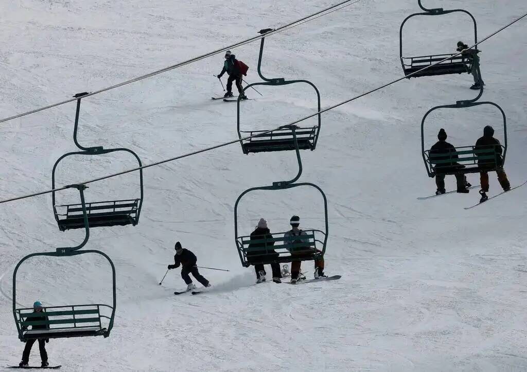 Esquiadores y snowboarders suben a los telesquíes de Lee Canyon el 26 de diciembre de 2022. (C ...