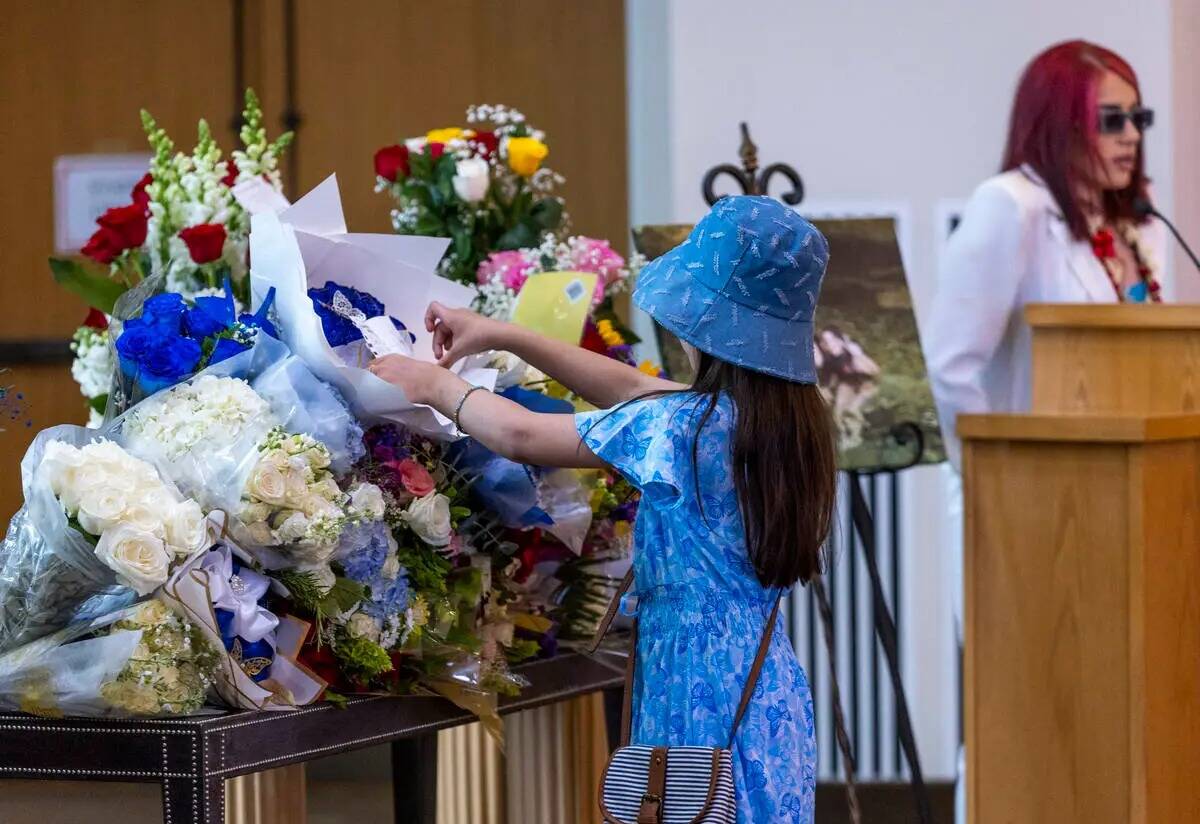 Nacy Diaz coloca un poema que escribió entre las flores durante un servicio funerario para Tab ...