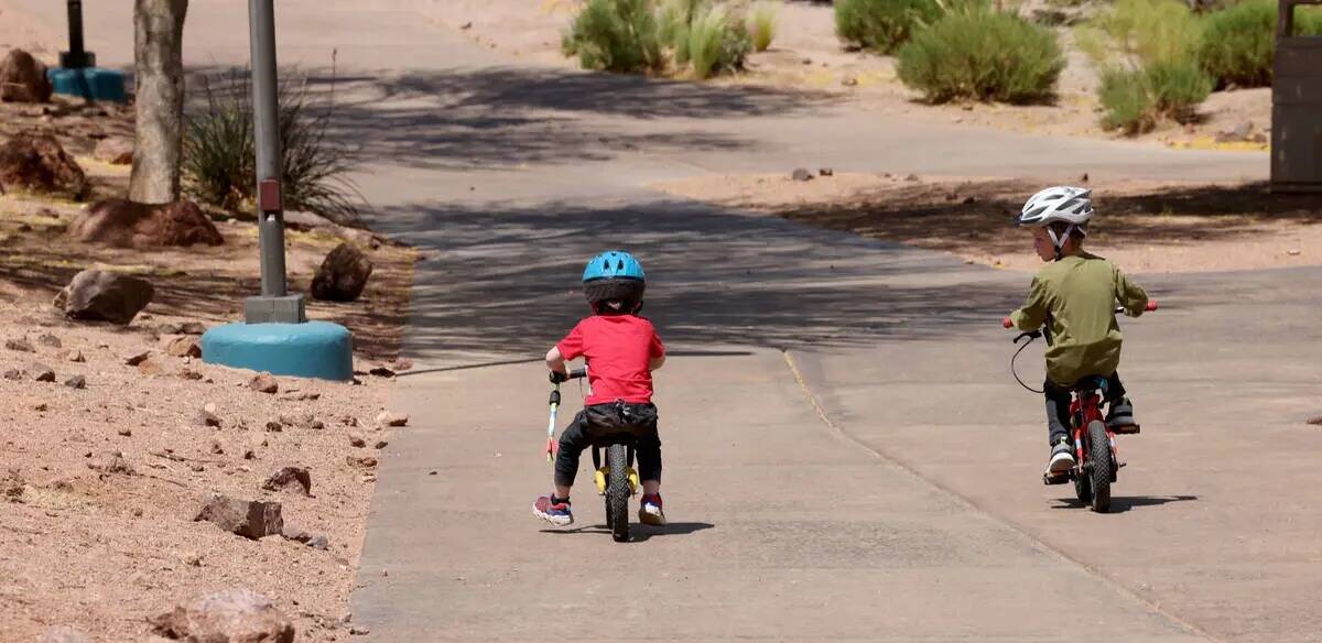 Asher, de 3 años, y su hermano Lucas, de cuatro, andan en bicicleta en Acacia Park de Henderso ...