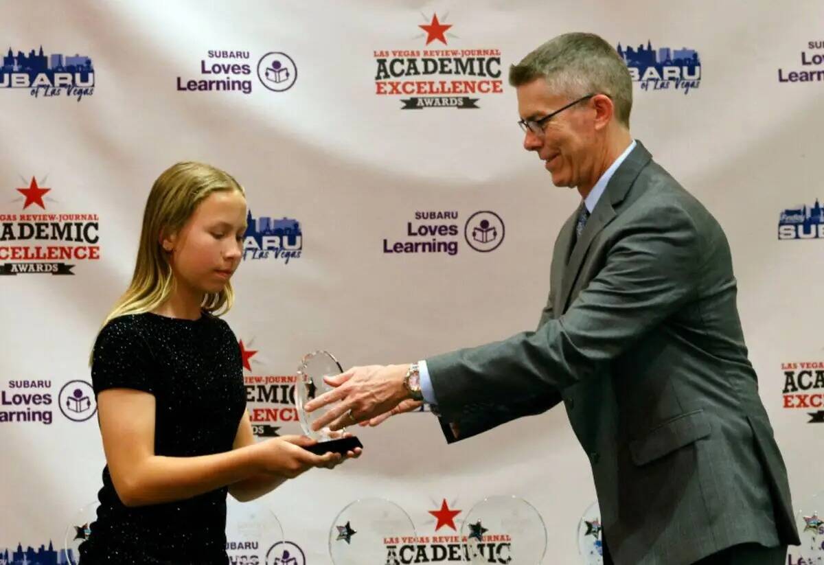 Elizabeth Frus, alumna de sexto grado de Garrett Junior High School, recibe un premio de manos ...