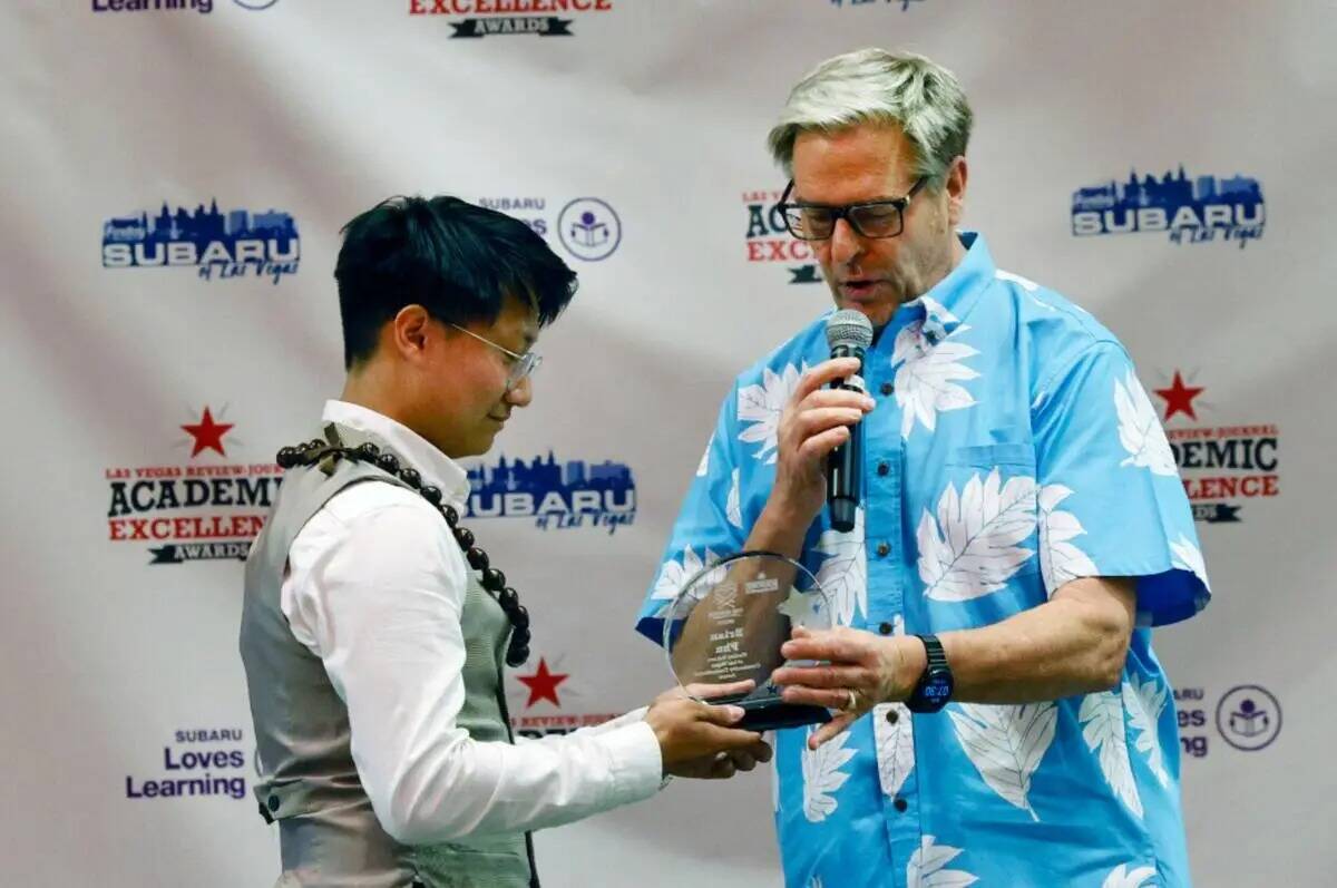 Brian Phu, a la izquierda, recibe un premio al compromiso con la comunidad de manos de Burton H ...