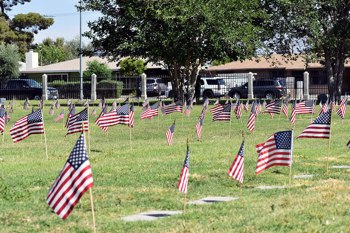 Cientos de banderas estadounidenses ondean en el césped del panteón, representando a más de ...