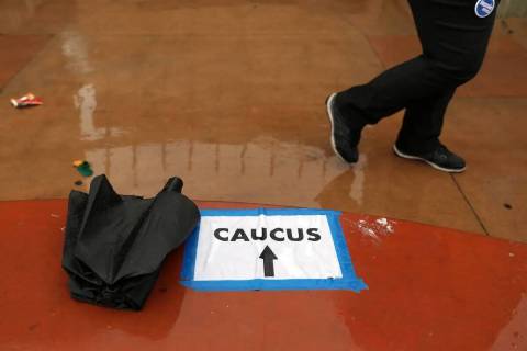 La lluvia cae mientras las personas llegan a registrarse para el caucus en East Las Vegas Commu ...