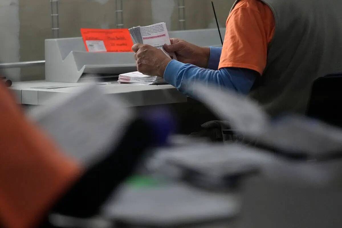Un trabajador electoral prepara los votos por correo en el Departamento Electoral del Condado C ...