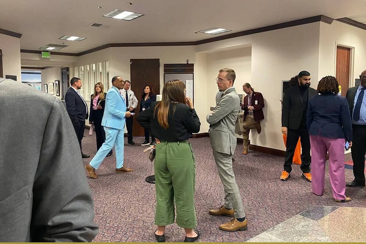 Legisladores y cabilderos se reúnen fuera de una sala de comité en el edificio de la Legislat ...