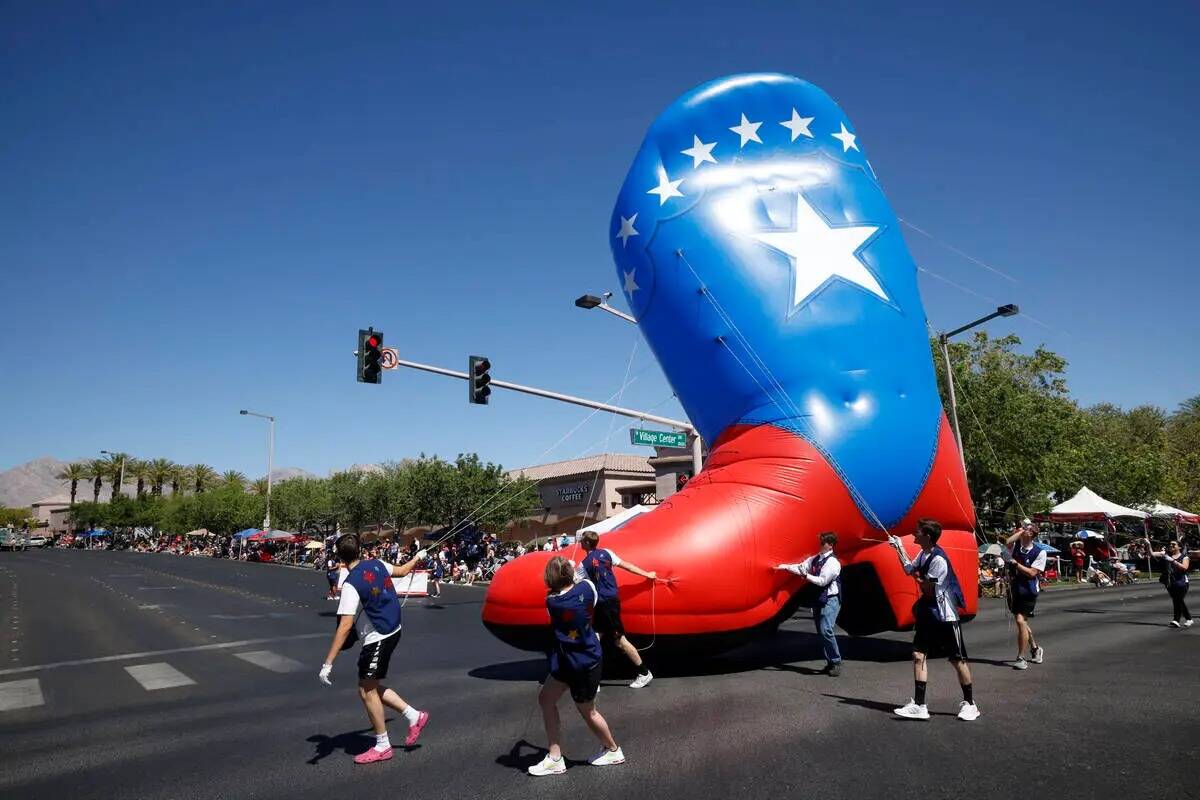 La gente lleva un gran globo inflable durante el Desfile Patriótico anual número 28 del Ayunt ...