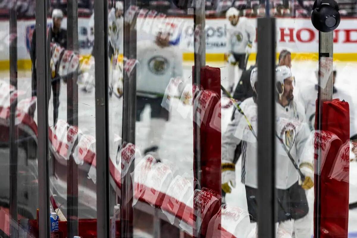 Los jugadores de los Golden Knights patinan sobre el hielo mientras cuelgan toallas en los asie ...