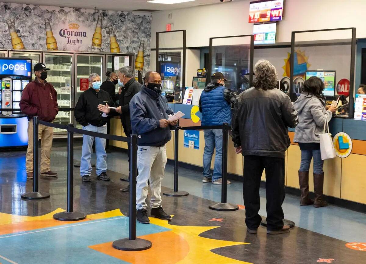 La gente hace fila dentro de la tienda de lotería Prime Valley mientras esperan para comprar l ...